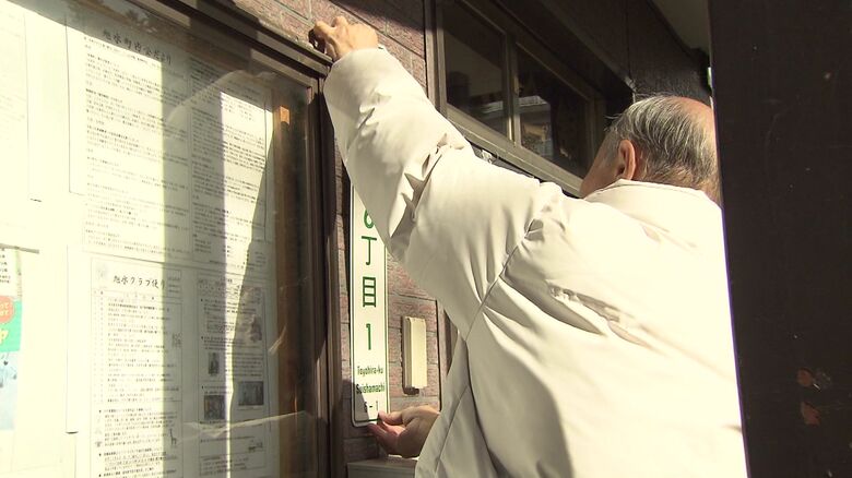 自ら表示板を付け替える高橋さん