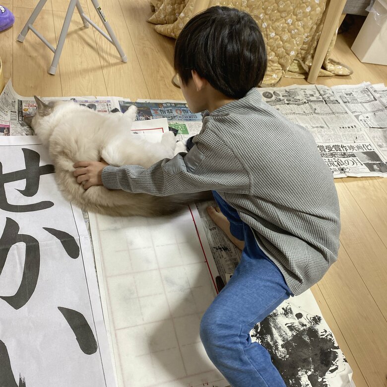 寝そべるルカくんを起こそうとする息子さん