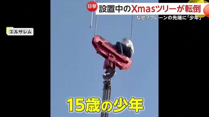 クレーンの先端に座り込む少年