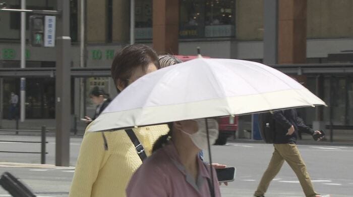 日傘をさして歩く街の人