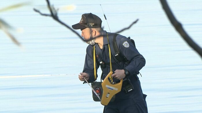 現場付近を調べる県警の捜査員(2月13日)
