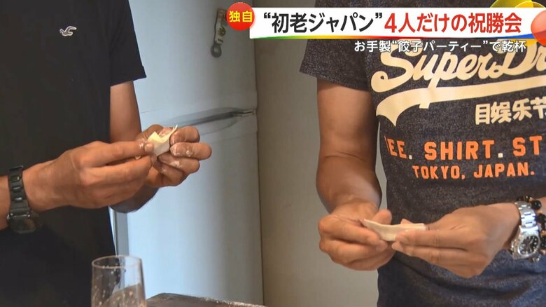 祝勝会の料理を準備する4人。ギョーザを手際よく包む。