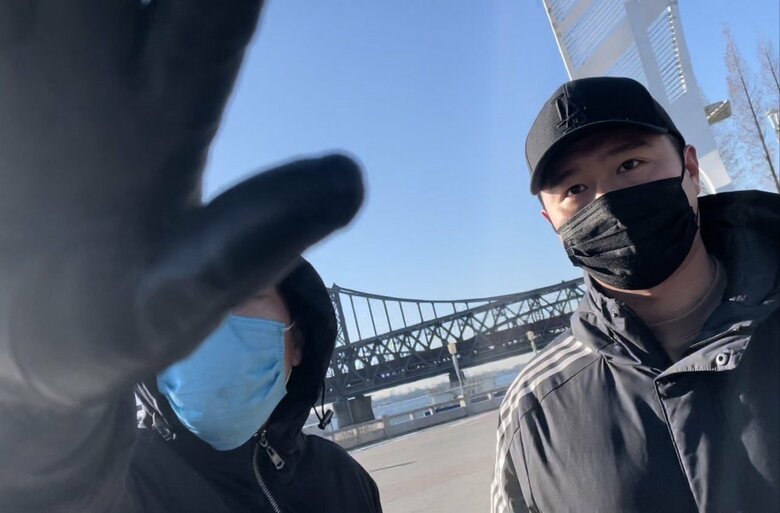 橋を通過する貨物列車の撮影を妨害する自称“旅行者”の男たち