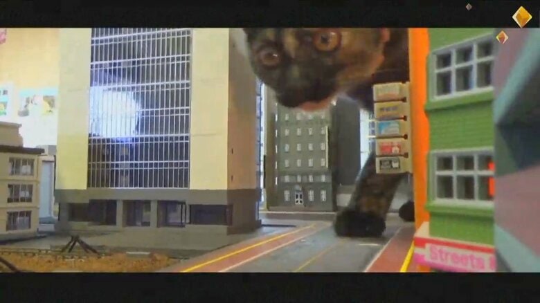 ジオラマのビルの間から現れたネコ