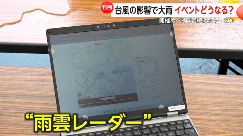 スタッフが雨雲レーダーを注意深く見つめていた