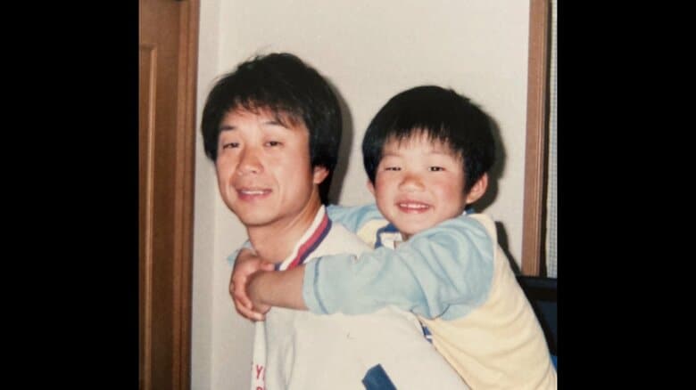 父・善文さんの背中で笑顔の森下