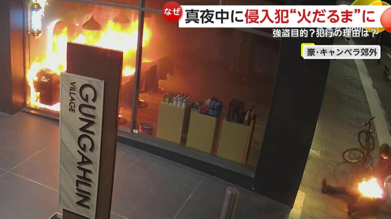 店の外で、火を消そうと転げまわる犯人（ACT Policing）