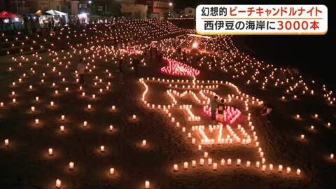 3000本のキャンドルで幻想的な光景　西伊豆の海岸でビーチキャンドルナイト開催　砂浜にやさしい光…夜空に花火が打ち上がって