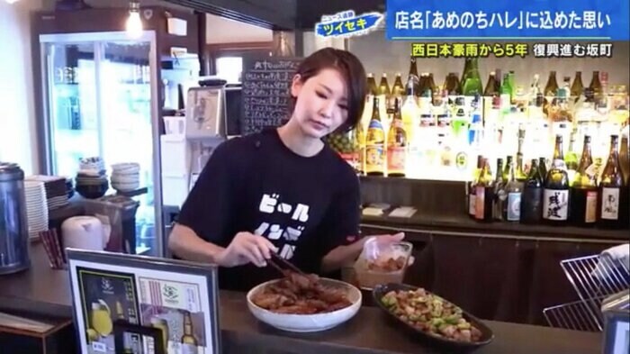 カウンターの大皿に総菜を盛る小田めぐみさん