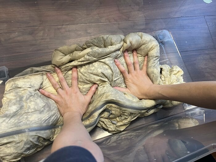 衣装ケースの底に押し付けるように水を切る（特集班撮影）