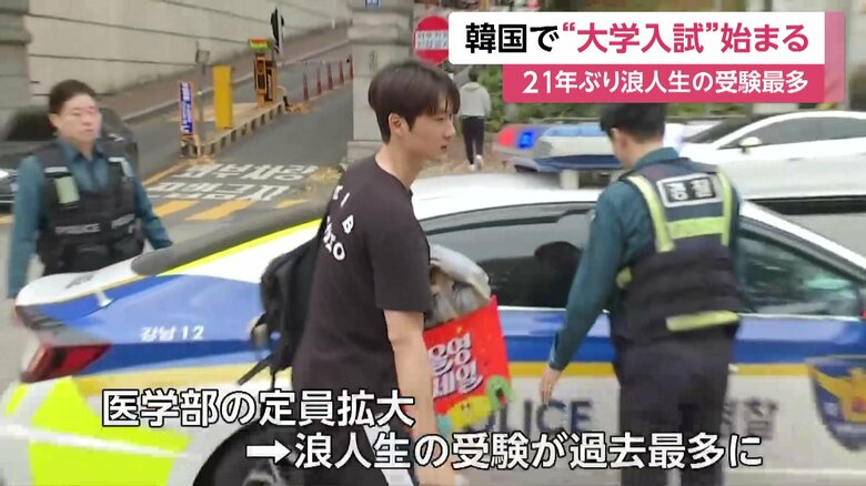 パトカーで会場入りする受験生