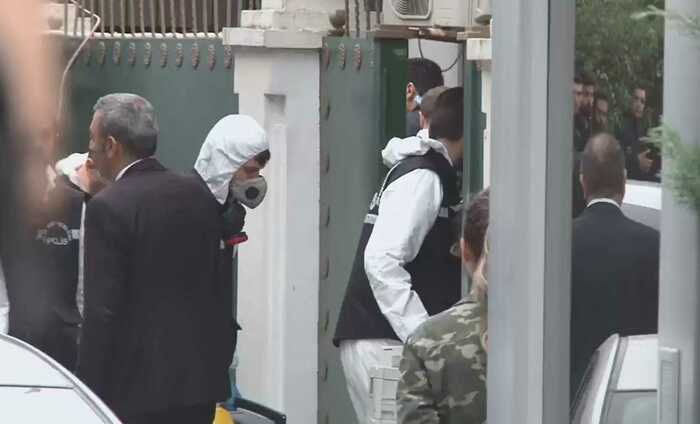 防護服で総領事館の調べに入る捜査員