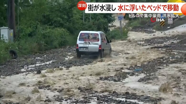 濁流の中を駆け上っていく車