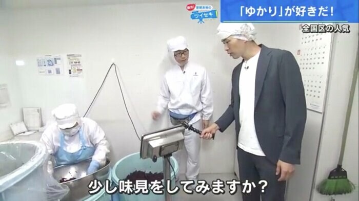 塩蔵赤しその検査室を案内する福田生産本部長(中央)