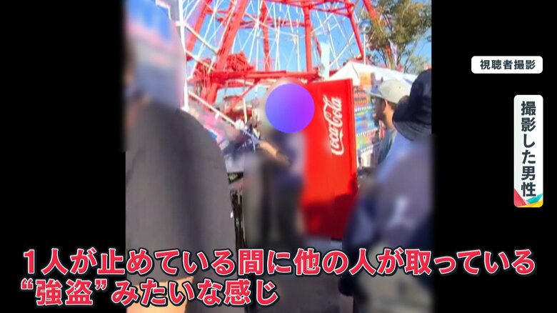 自販機の真横でのぼりを外そうとしている人