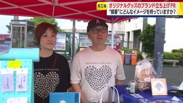 蝶番デザインTシャツを着て販売する伊藤社長夫妻