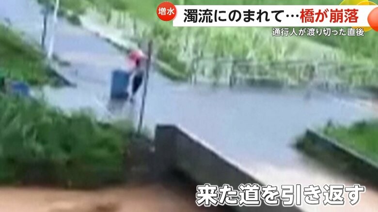 今にも氾濫しそうな状況にもかかわらず、橋へと引き返す人