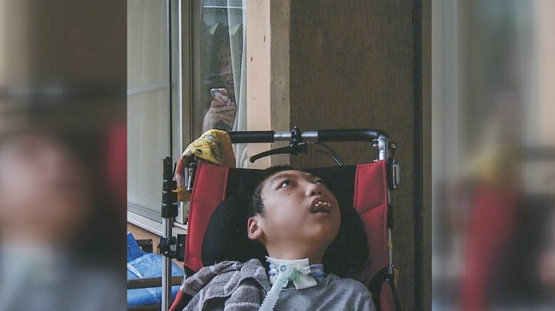 息子・瑞樹さんを窓からのぞく山本さん