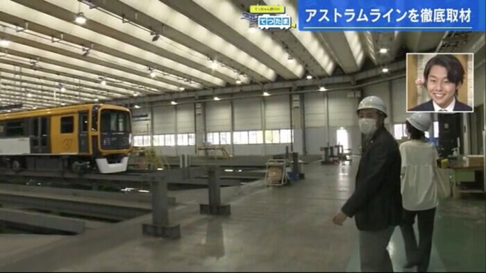 高岡さんに車庫を案内してもらう野川アナ