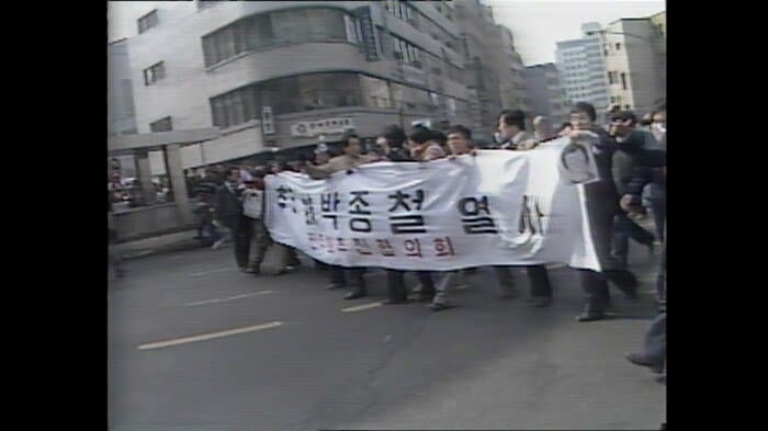 横断幕や朴鐘哲さんの遺影を掲げ行進するデモ隊（1987年）