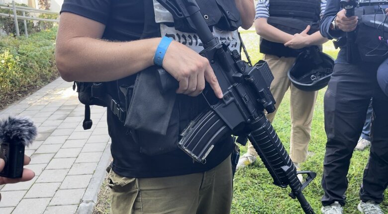 手には本業のカメラではなく自動小銃が