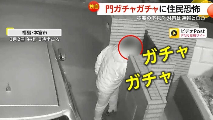 門のノブをガチャガチャする男