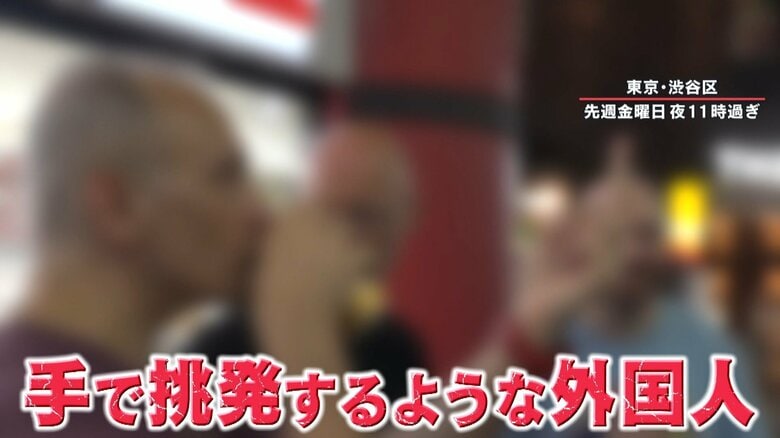 挑発するようなハンドサインをする外国人