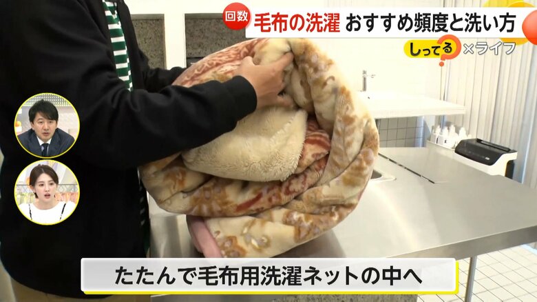 毛布を折り込んで畳み、毛布用の洗濯ネットに入れる様子