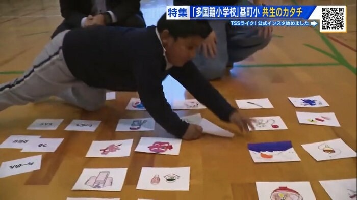 体育館で大学生と子どもたちがカードゲームを楽しむ