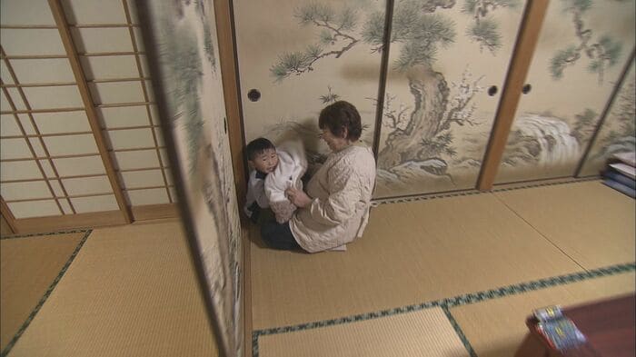 毛布にくるまって隠れる男の子(2019年)
