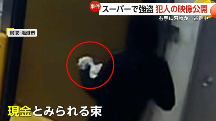 左手に現金とみられる束を持った犯人（鳥取県警提供）