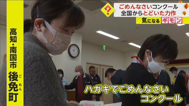 届いたハガキに目を通す人々