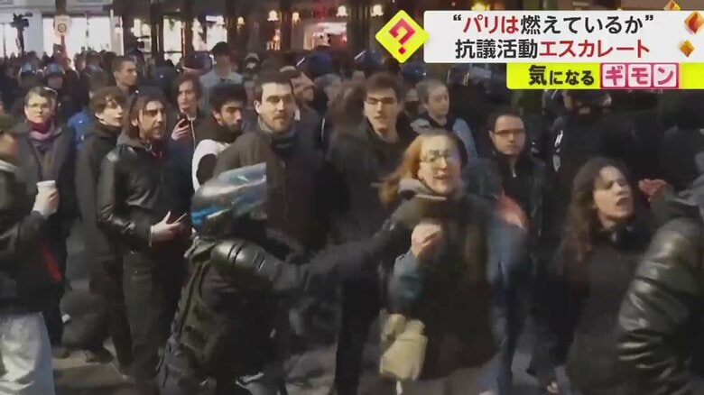 女性と小競り合いをする警察
