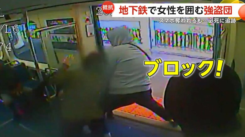 追いかけようとする女性を体でブロックする大柄な男