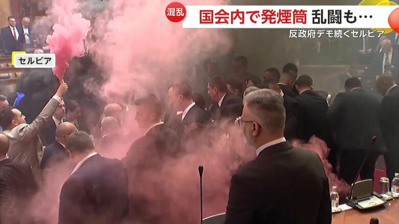 大音量の警報音が鳴り響き、ピンク色の煙が立ちこめる国会（4日、セルビア・ベオグラード）