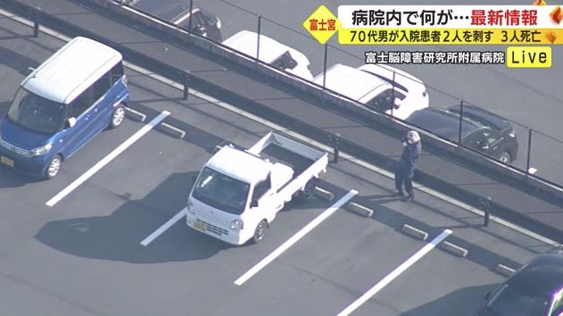 軽トラックを撮影する警察官