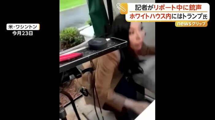 銃声を聞き身をかがめる記者