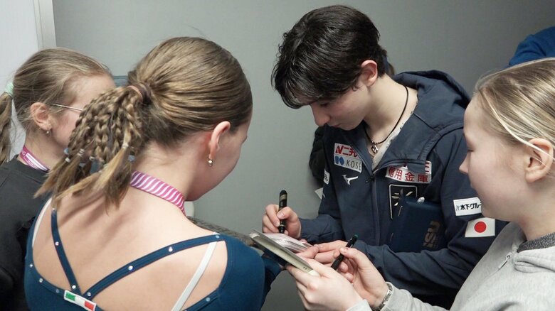 サインを求められて応じる中田