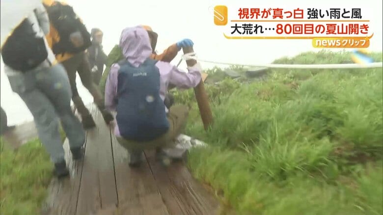 強い雨風に耐える登山客
