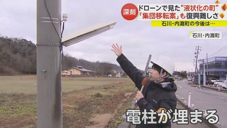 液状化の影響で街灯が人の手に届く位置まで下部が埋まってしまった電柱も