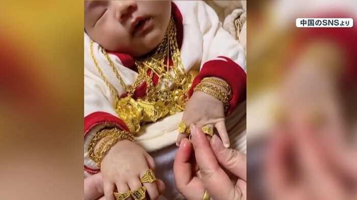 金の装飾で着飾られる赤ちゃん