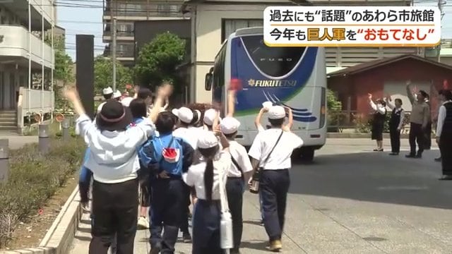 選手らを乗せたバスを見送る地元の児童たち