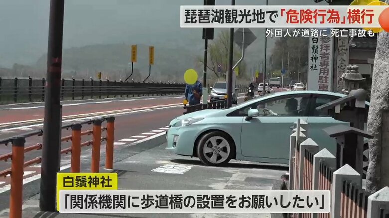 大鳥居を近くから撮影しようと、車が行き交う道路を無理やり渡る観光客