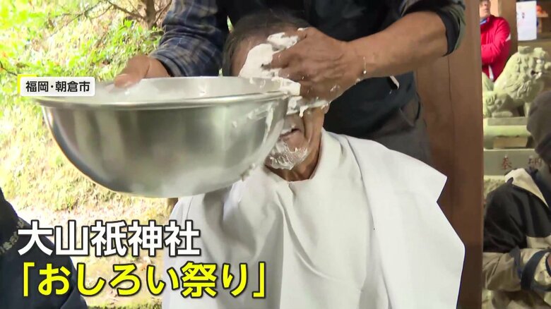 顔を白く塗りたくられる男性