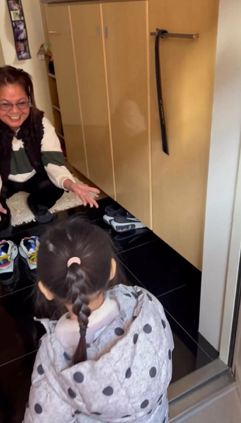 しゃがんで腕を広げる祖母