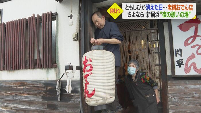 雨の中、最後のちょうちんを出す 店主の落藤通正さんと妻・シヅエさん