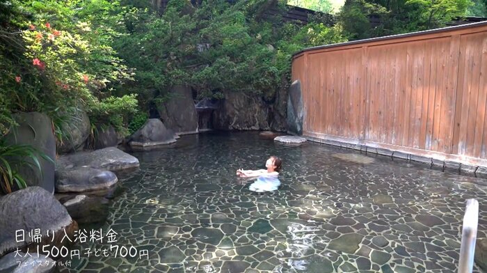 奥には滝が流れている ※特別にタオルを着用しています