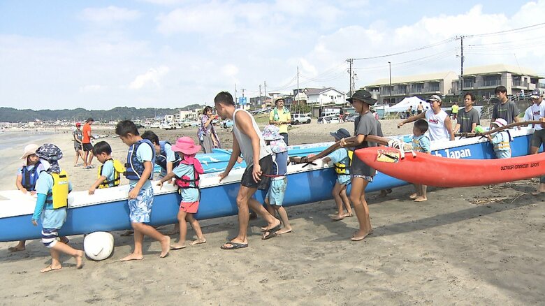 皆で協力してカヌーを運ぶ様子