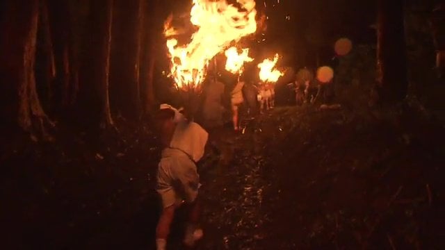 身長より長い松明を担ぎ　標高230ｍの山頂を目指す