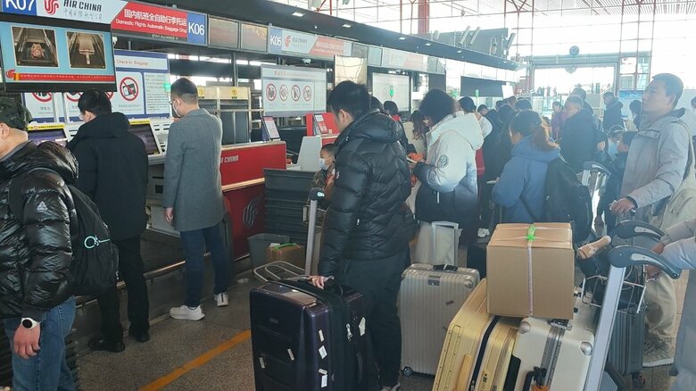 北京首都国際空港で搭乗手続きをする中国人旅行客
